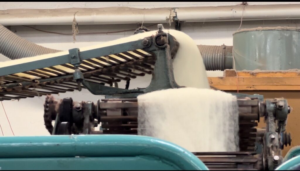 Machine à traiter la laine de mouton, illustrant la production durable de l'entreprise "Laines sous les Pommiers".