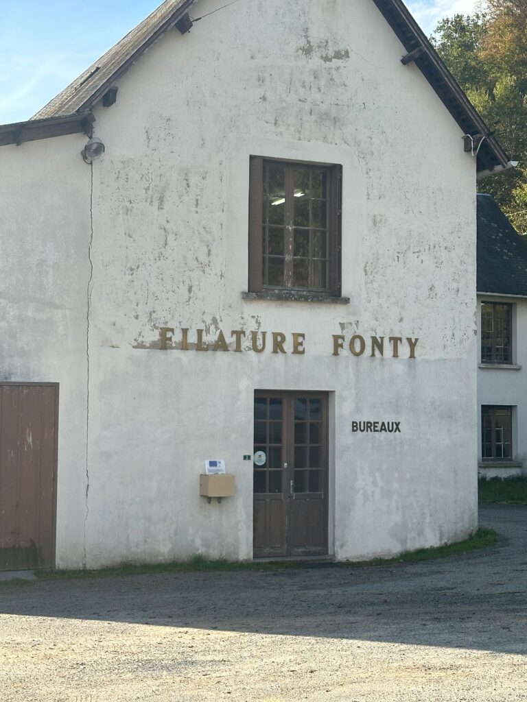 Façade d'un bâtiment marqué "Filature Fonty", siège de l'entreprise spécialisée en laine durable.