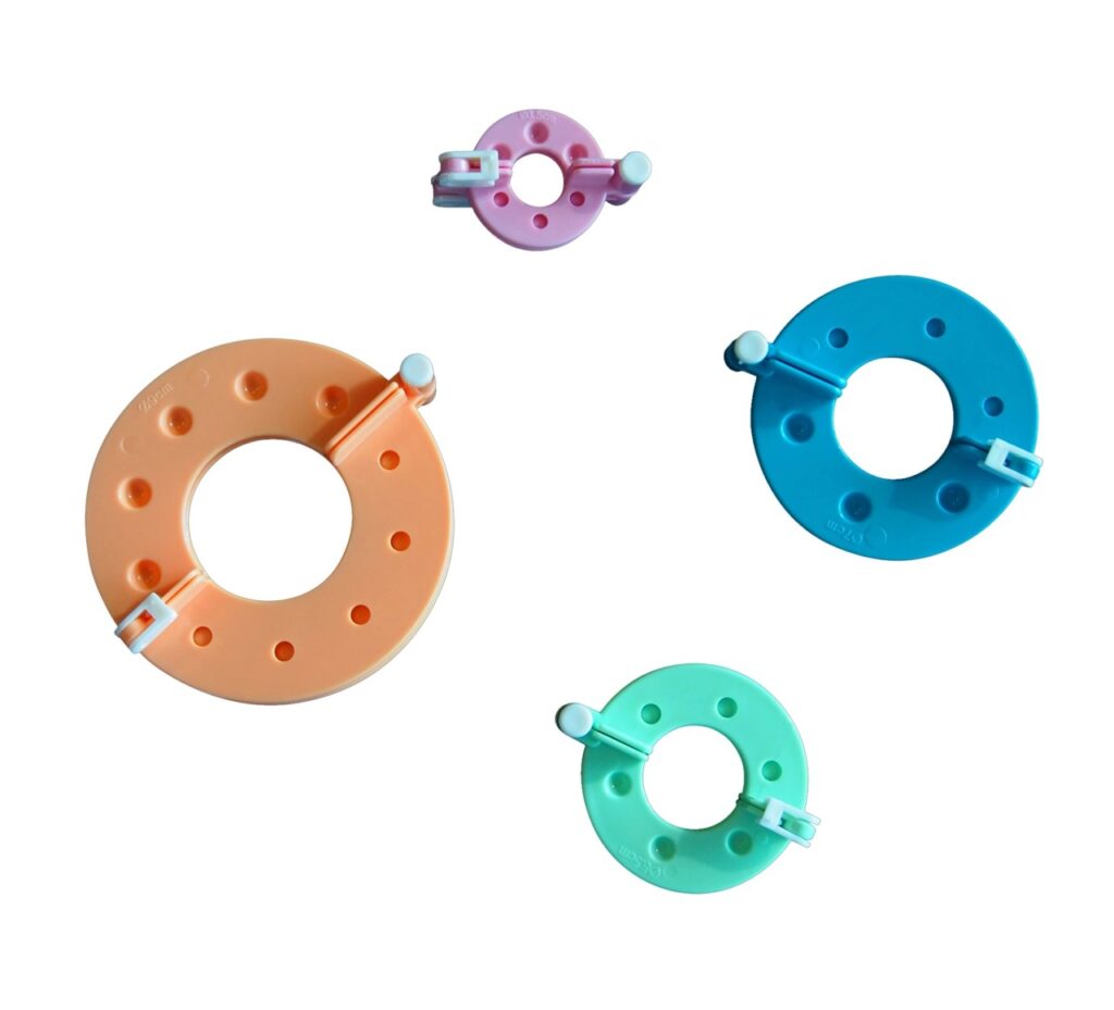 Assortiment d'anneaux colorés en plastique pour la transformation de la laine au sein de l'entreprise Laines sous les Pommiers.