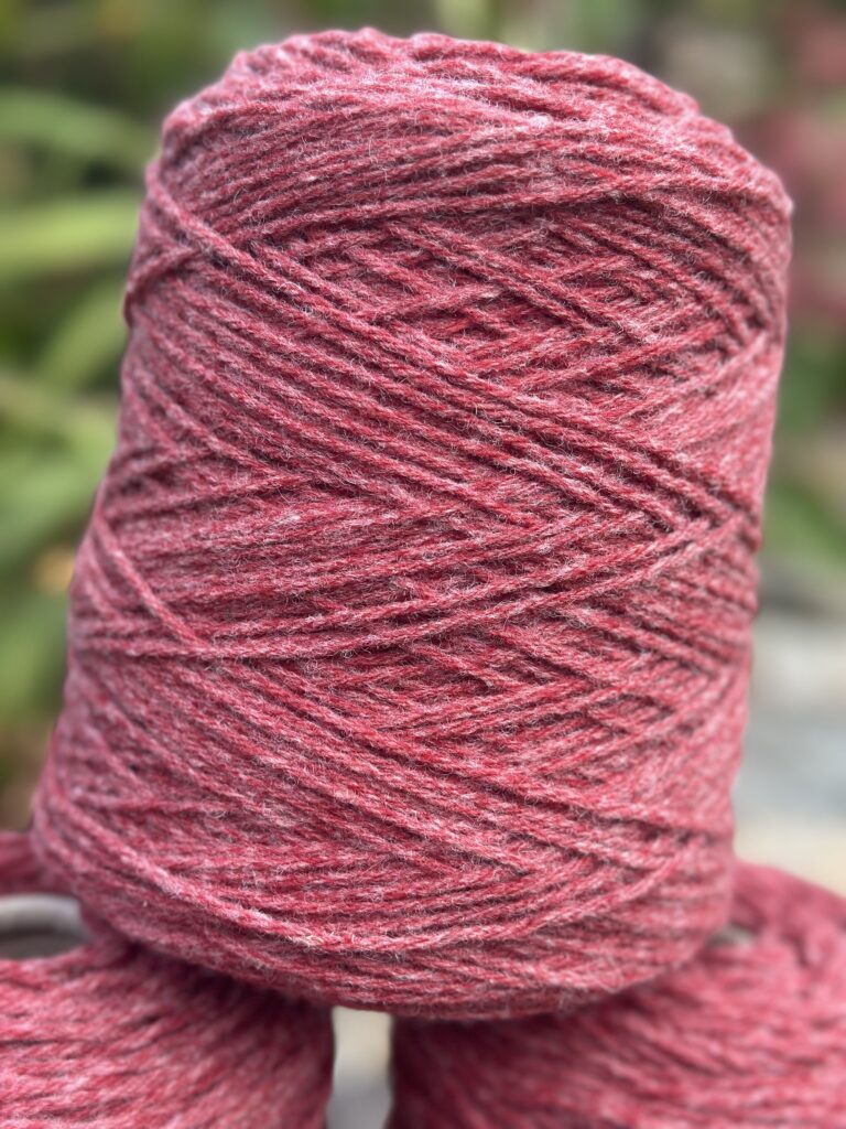 Pelote de laine rouge marbré, produite localement par Laines sous les Pommiers en Normandie. Artisanat durable.